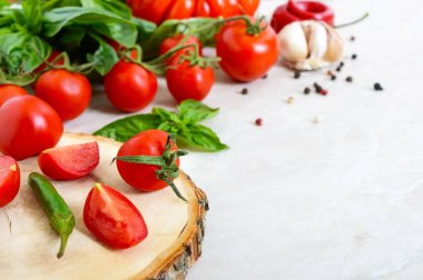 Kiraz domates şube, sarımsak, taze fesleğen, hafif bir arka plan üzerine biber. Soslar yapmak için malzemeler. İtalyan mutfağı. Projeniz için boş alan.