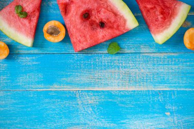 Karpuz nane yaprakları ve kayısı mavi ahşap zemin ile dilim. Projeniz için boş alan.