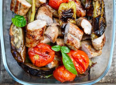 Sulu sosis ve doğa arka plan üzerinde bir cam kasede ızgara sebze. Açık havada akşam yemeği. Bahçe partisi. Üstten görünüm. Yakın çekim