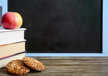 Okul hazırlıkları eğitim kavramı. Kitaplar, yararlı tam buğday kurabiye ve elma yazı tahtası önünde sınıf masada. Uzay kopyalayın. Sağlıklı ve apple ile akıllı olacak tam tahıllı çerezleri her gün okula geri ne zaman