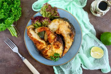 Büyük biftek ızgara balık ile marul bir plaka üzerinde. Üstten görünüm