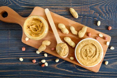 Ahşap bir masa üzerinde bir seramik kase fıstık ezmesi. Amerikan mutfağının geleneksel bir ürünüdür. Üstten görünüm.