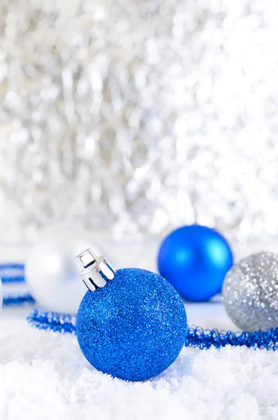 New Year banner with blue, silver and white Christmas balls in snow on abstract winter background. Xmas decoration with copy space. Merry christmas.