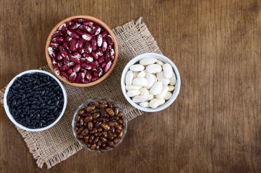 Renkli ham fasulye kase ahşap bir masa üzerinde de ürün yelpazesine. Sağlıklı gıda, diyet, beslenme kavramı. Baklagiller - vegan protein kaynağı.