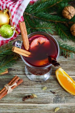 Sıcak mulled şarap cam kupa ahşap bir masa üzerinde. Dayalı şarap, meyve suyu, baharatlar, çeşnilikler, meyve kokulu geleneksel kış içki. Yakın çekim