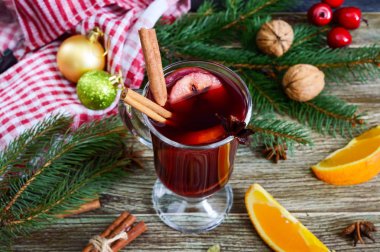 Sıcak mulled şarap cam kupa ahşap bir masa üzerinde. Dayalı şarap, meyve suyu, baharatlar, çeşnilikler, meyve kokulu geleneksel kış içki.
