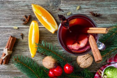 Sıcak mulled şarap cam kupa ahşap bir masa üzerinde. Dayalı şarap, meyve suyu, baharatlar, çeşnilikler, meyve kokulu geleneksel kış içki. Yakın çekim. Üstten görünüm