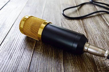 Altın mikrofon kablosu üzerinde kopya alanı ile ahşap bir masa ile. Müzikal Tema. 