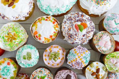 Beyaz bir arka plan üzerinde birçok farklı Paskalya kek. Üstten görünüm. Geleneksel tatlı ekmek dekore edilmiş beze ve tatlılar.