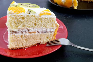 Büyük bir parça meyve sünger kek siyah bir arka plan. Festival kek.