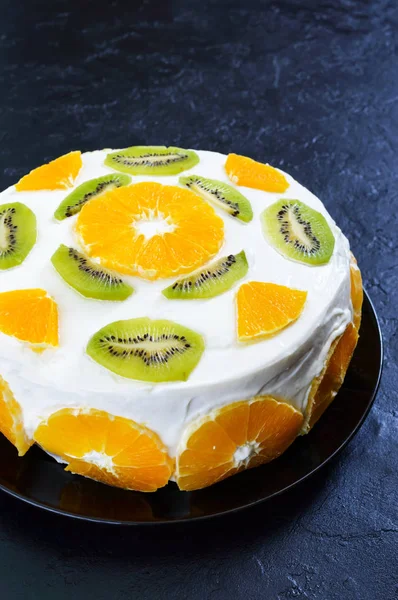 Fruit cake on a black background, copy space. Vertical view. Festive cake.