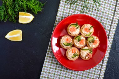 Krem peynir ve bir kırmızı plaka üzerinde tuzlanmış somon ile tartlets. Bir parti için lezzetli hafif aperatif. Parmak gıda. Üstten Görünüm.