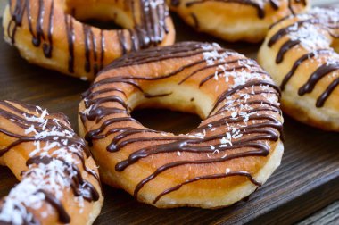 Koyu ahşap arka plan üzerinde çikolata ve Hindistan cevizi pul ile ev yapımı klasik çörek. Yakın çekim.