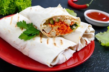 Siyah bir zemin üzerine lezzetli shawarma sandviç. Burrito ızgara tavuk ve sebze, yeşillik ile tamamladı. Fajitas, pide. Geleneksel Orta Doğu meze. Meksika mutfağı