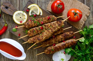 Ahşap bir masada lezzetli Lula kebap. Ahşap şiş, ızgarada doğranmış et. Doğu mutfağı. Üst görünüm, düz yatıyordu.