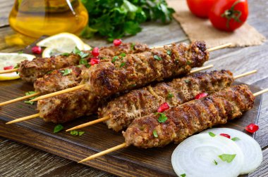 Ahşap bir masada lezzetli Lula kebap. Ahşap şiş, ızgarada doğranmış et. Doğu mutfağı.