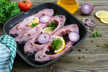 Ahşap bir masada ızgara Pan Çiğ biftekler Nehir balığı. Yemek pişirmek için hazır sazan.