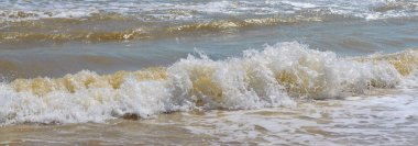 Güneş ışığında sahilde dalgalar. Afiş. Denizin güzel manzarası. Seascape.