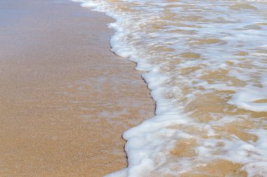 Kumlu plajda güneş ışığında mavi deniz yumuşak dalgalar. Kopya alanı ile tropikal kumlu plaj arka plan.