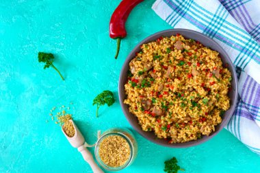 Tavuk lu ve sebzeli bulgur. Parlak bir arka plan üzerinde lezzetli sağlıklı sıcak salata. Bulgur pilavı. Üst görünüm, düz yatıyordu.