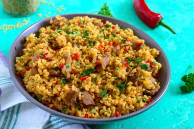 Tavuk lu ve sebzeli bulgur. Parlak bir arka plan üzerinde lezzetli sağlıklı sıcak salata. Bulgur pilavı. Yakın çekim