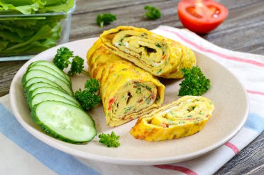 Omlet, tahta bir masada sebze ve otlar ile yumurta rulo. Lezzetli sağlıklı kahvaltı.