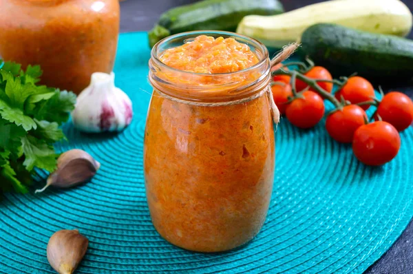 Delicious squash caviar in a jar on the table. Homemade caviar with zucchini, garlic, carrots, tomato sauce. Vegan cuisine.