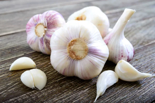 Garlic cloves, garlic bulb on wooden background. Fresh garlic close up. Concept of healthy food.