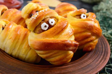 Komik sosis ve pirzola gözleri ile hamur mumyalar, masada ketçap. Cadılar Bayramı yemeği. Yakın çekim