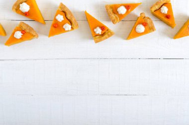 Beyaz ahşap arka planda geleneksel balkabağı turtası parçaları. Şükran Günü teması. Sağlıklı yemek, gurmeler için tatlı. Geleneksel sonbahar atıştırması. Boşluğu kopyala.