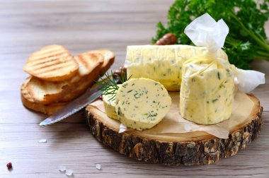Sandviç ve biftek için tereyağlı bitki. Tahta bir tahtanın üzerinde kesilmiş Herb Butter 'ın bir parçası. Ev yapımı İtalyan yemekleri..