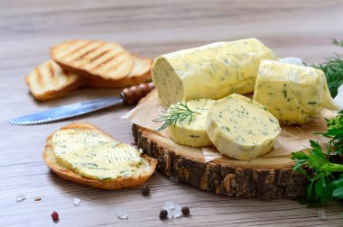 Sandviç ve biftek için tereyağlı bitki. Tahta bir tahtanın üzerinde kesilmiş Herb Butter 'ın bir parçası. Ev yapımı İtalyan yemekleri..