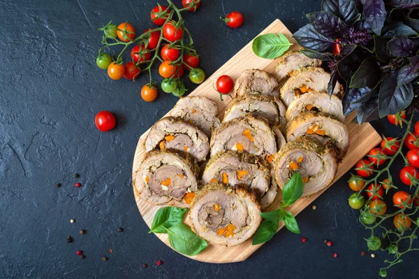 Delicious meat rolls stuffed with vegetables with cherry tomatoes and basil. Festive dish. Flat lay.