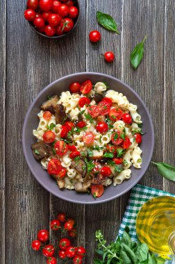 Izgara patlıcanlı makarna arması, kiraz domatesleri ve otlar. Lezzetli sıcak salata. Üst görünüm.