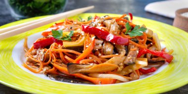 Kore patlıcanları. Patlıcanlı baharatlı sebze salatası, dolmalık biber, havuç, siyah arka planda bir tabakta soğan. Kapat.