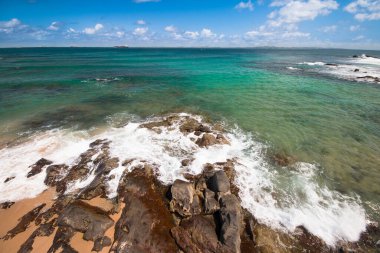 Sahilde kayalar ve mavi gökyüzü.