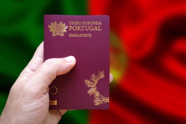 Arka planda Portekiz bayrağı olan Portekiz pasaportu tutan bir adam. Portekizce yazılmış: Avrupa Birliği Portekiz. Pasaport