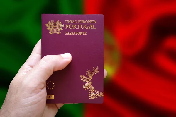 Ręka Mężczyzny Trzymająca Portugalski Paszport Zdekoncentrowaną Flagą Portugalską Tle Napisane — Zdjęcie stockowe