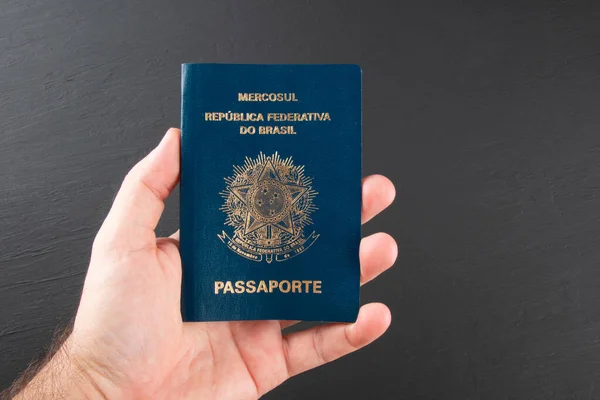 Mão Segurando Passaporte Brasileiro Com Fundo Preto — Fotografia de Stock
