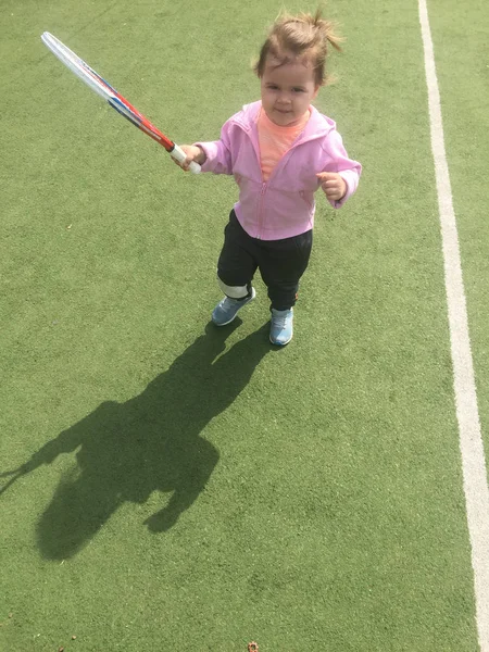 bir tenis çim kortu üzerinde bir raket ile güzel genç tenis oyuncusu, çocuk tenis eğitimi