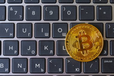 Laptop klavye siyah düğmeleri ve beyaz işaretleri olan altın bitcoin