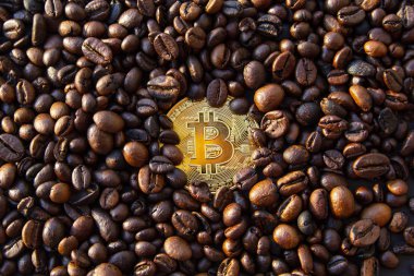 Altın sikke bitcoin pırıltılar kahverengi kahve çekirdekleri içinde.