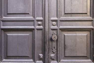 Arka plan. Çatlaklar, anahtar delikleri ve kapı kolu ile eski bir ahşap kapı.