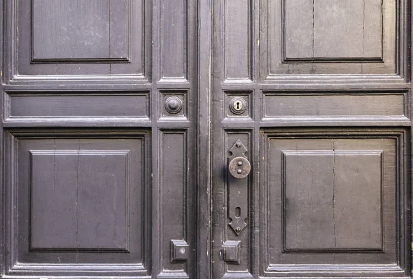 Arka plan. Çatlaklar, anahtar delikleri ve kapı kolu ile eski bir ahşap kapı.