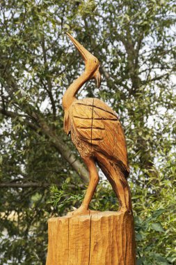 Ahşap arka plan ağaç ve yeşil yaprakları üzerine yapılan leylek