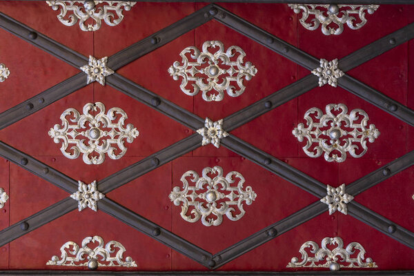 Красный металлический фон с черными линиями и блестящими узорами
