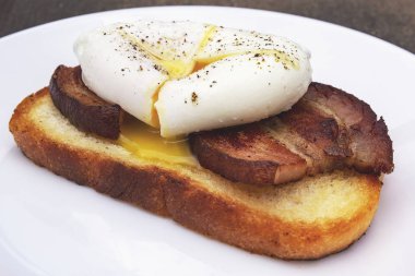 Kahvaltı. Kızarmış domuz pastırması ve bir dilim kızarmış ekmek haşlanmış yumurta