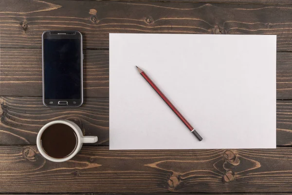 Arka plan, beyaz bir kağıt yaprağına, telefon ve koyu ahşap bir masa üzerinde kalem