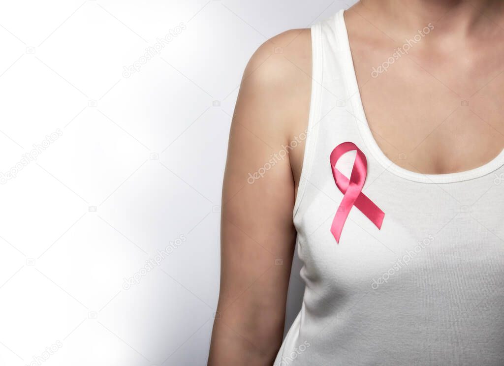 Girl in a white T-shirt with a pink ribbon on her chest.