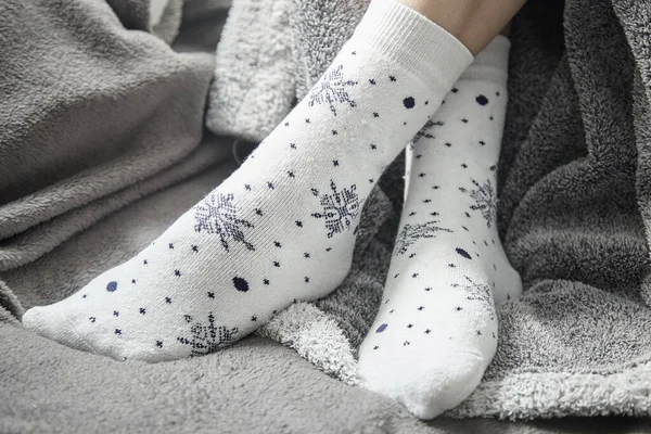 White socks with drawn snowflakes. Legs in white sock closeup with blur.